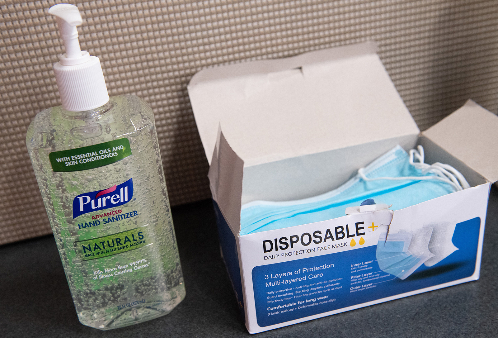 A bottle of Purell hand sanitizer and a box of disposable masks 