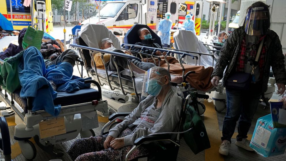 Patients wait at a temporary treatment area outside Caritas Medical Centre in Hong Kong, Saturday, Feb. 26, 2022. For two years, Hong Kong successfully insulated most of its residents from COVID-19 and often went months without a single locally sprea